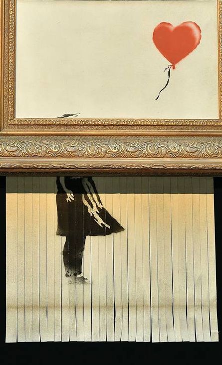 fotografia do quadro que teve metade picotado na parte inferior: temos a moldura e dentro dela o desenho de um balão no formato de coração. Na parte abaixo da moldura, a parte picotada mostra o corpo de uma menina com vestido de perfil
