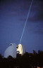 Com 2,7 metros, o Telescpio Smith J. Harlan no Observatrio McDonal (EUA)  usado para apontar um feixe de laser para um espelho posicionado na superfcie da lua. <br> O laser  a origem de uma das descobertas militares. Na figura v-se um feixe de laser disparado a partir do Observatrio MacDonal, Texas (EUA), em direo a espelhos estacionrios localizados na superfcie da Lua. Com esta tecnologia  possvel acompanhar-se o movimento da Lua em sua rbita com preciso de milmetros (ou maior). O advento do laser acarretou, contudo, inmeras outras aplicaes. <br><br> Palavras-chave: observatrio, telescpio, astronomia, cincia, filosofia da cincia