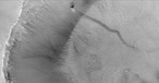  Astronomia planetária ou ciências planetárias: um "dust devil" (literalmente, demônio da poeira) marciano. A fotografia foi captada pela NASA Global Surveyor em órbita à volta de Marte. A faixa escura e longa é formada pelos movimentos em espiral da atmosfera marciana (um fenómeno semelhante ao tornado). O "dust devil" (o ponto preto) está a subir a encosta da cratera. Os "dust devils" formam-se quando a atmosfera é aquecida por uma superfície quente e começa a rodar ao mesmo tempo que sobe. As linhas no lado direito da figura são dunas de areia no leito da cratera.